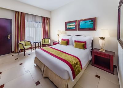 Room with double bed with decorations at Ajman Hotel