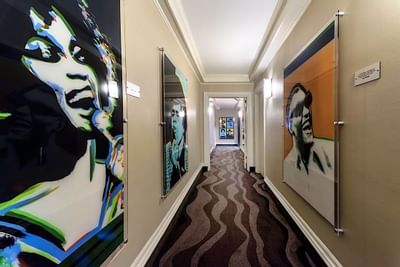 A hallway with portraits of famous musicians at Artmore Hotel