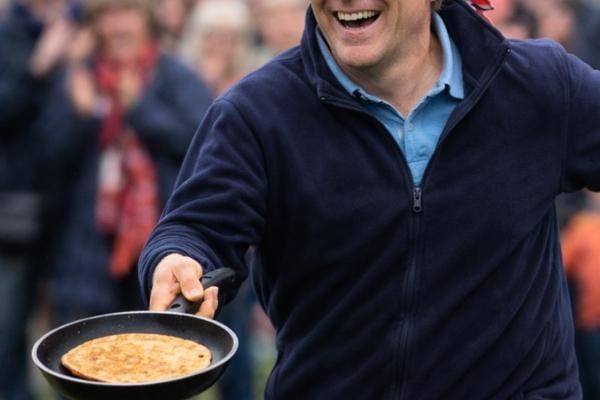 Man with frying pan racing at Buckingham's Pancake Race 