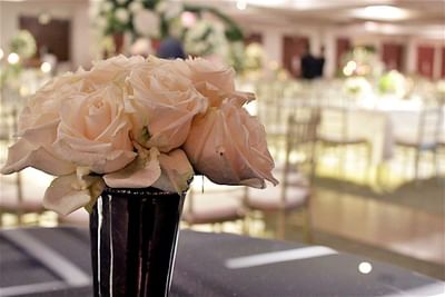 A bouquet of pale pink roses in a black vase at the center of a table in Hotel Mykonos