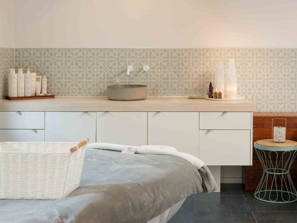 Wildfire Day Spa with decorative tiles, skincare products, and a massage table at Mercure Kooindah Waters