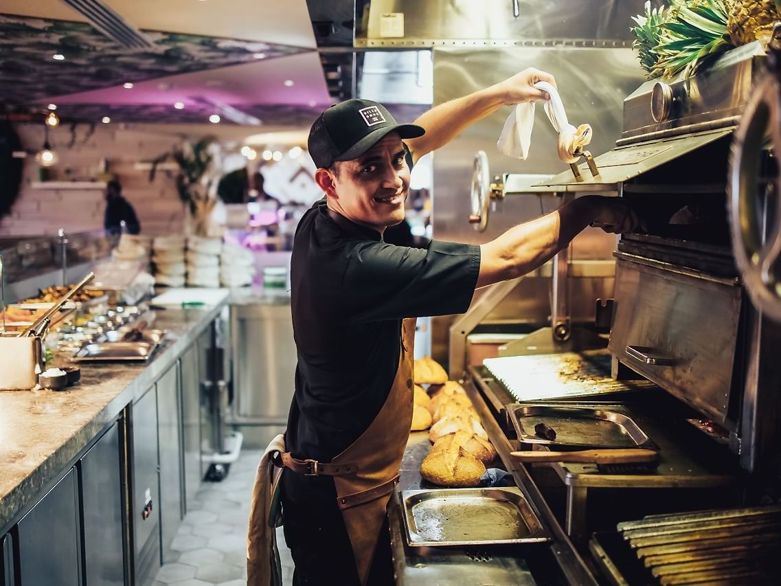 Chef posing while preparing meals in Pacific Groove Restaurant & Lounge at Paramount Hotel Dubai