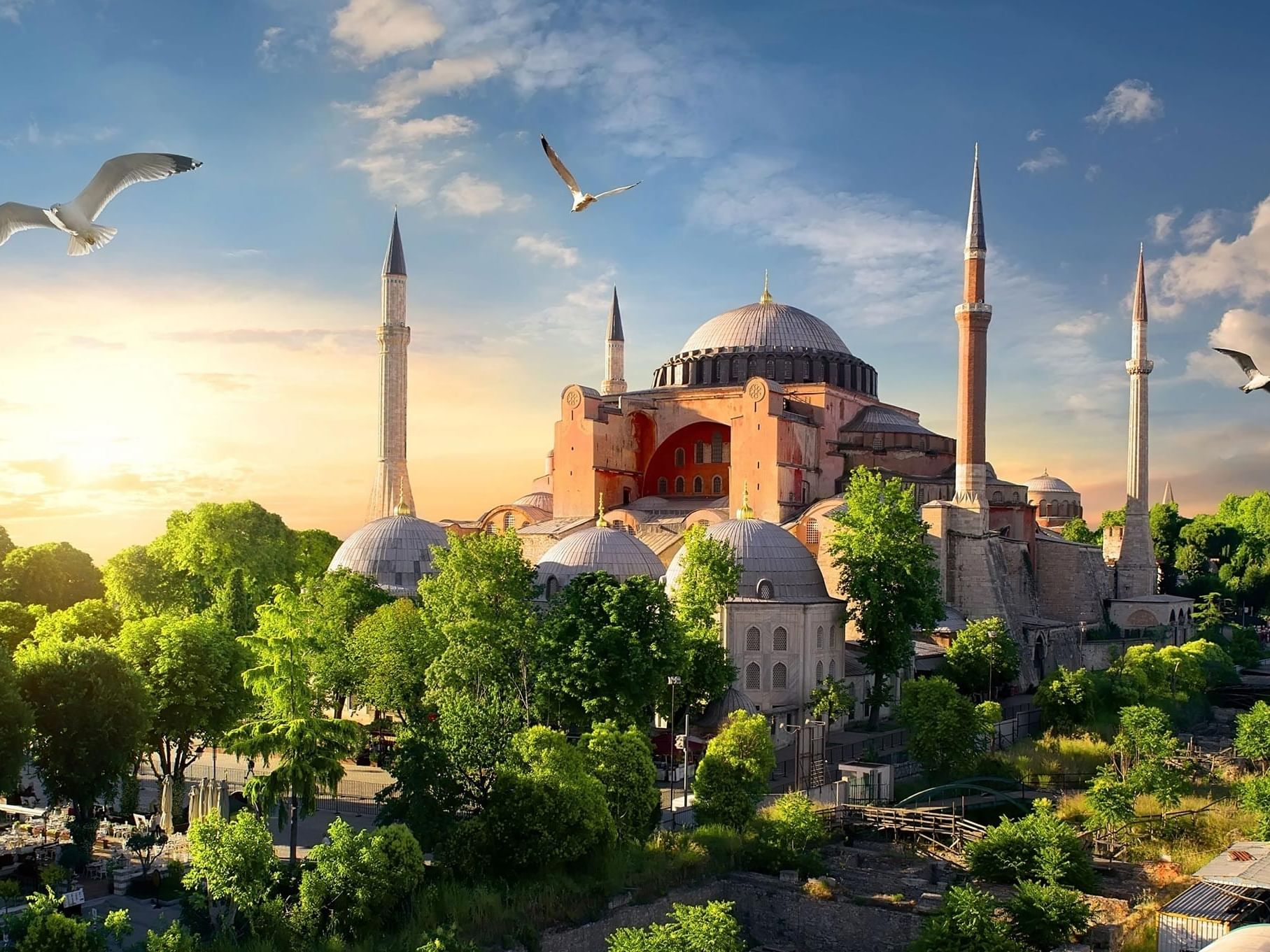 Sunset view of Hagia Sophia Grand Mosque with surrounding greenery near Titanic Hotels