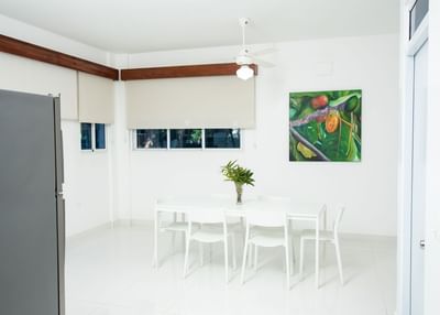 White-themed dining room with a beautiful painting in Two-Bedroom Suite at Cha Cha Hotel