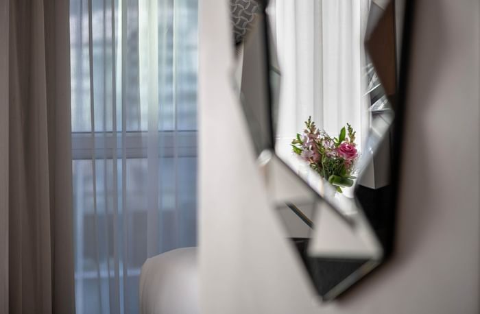 Miroir de chambre avec bouquet de fleurs et rideau élégant chez Warwick Le Crystal Montreal