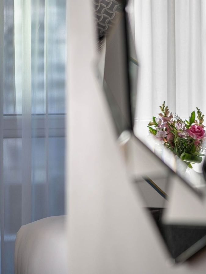 Mirror with flowers reflecting curtains in Penthouse René-Lévesque at Warwick Le Crystal Montreal