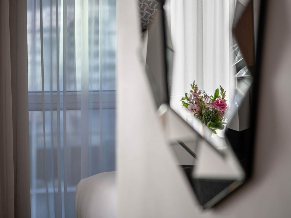 Miroir reflétant des fleurs dans la chambre « Penthouse Drummond » de l'hôtel Warwick Le Crystal – Montréal.