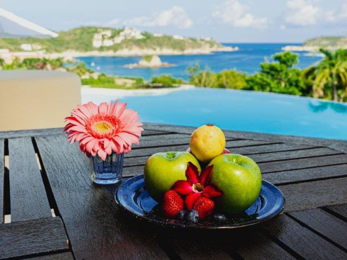 King Presidential Suite Fresh fruit plate, and a pink flower on a table near the infinity pool at Quinta Real Huatulco
