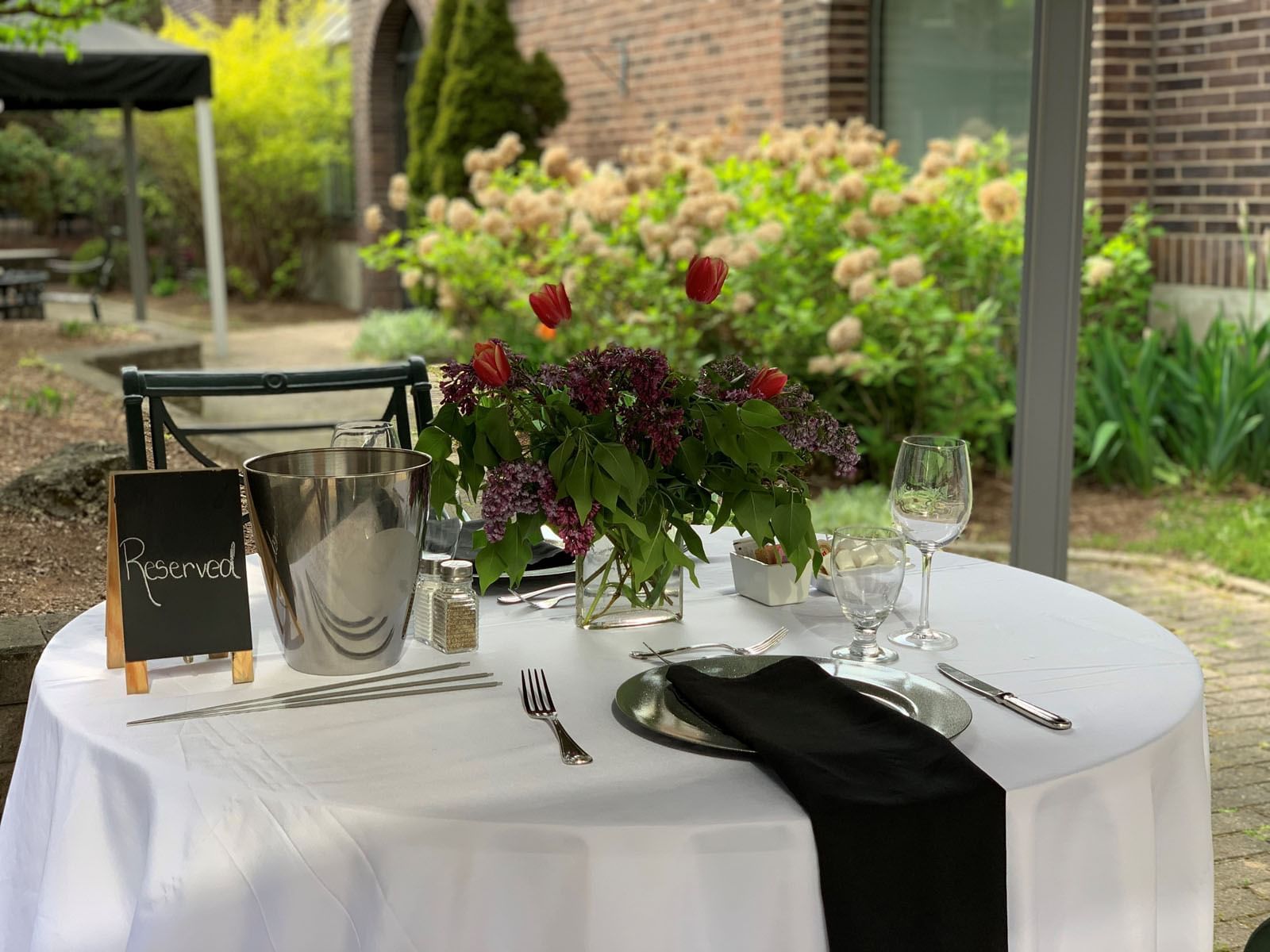 dining table in a garden with flowers at The Inn of Waterloo
