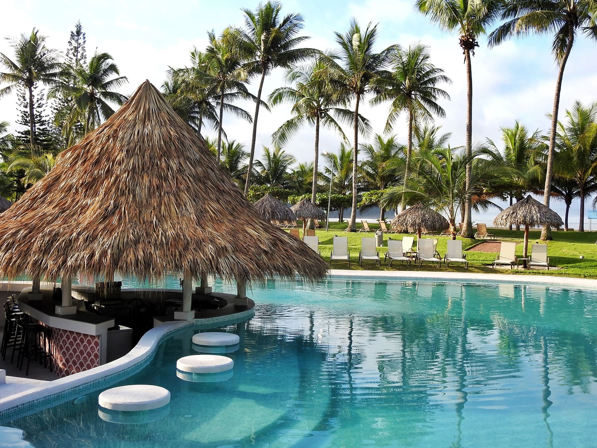 Outdoor pool with a private patio & sunbeds at Fiesta Resort