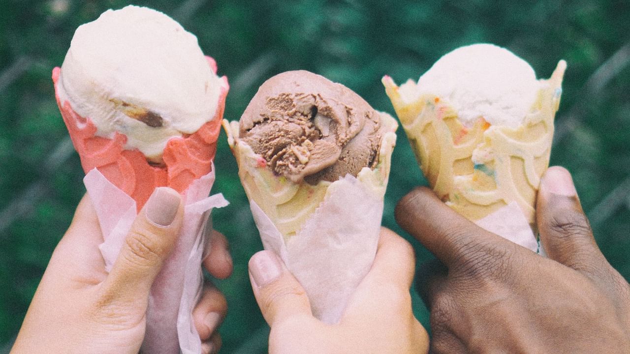 Close-up of 3 hands holding ice cream cones at Midnight Sun, a Coast Hotel