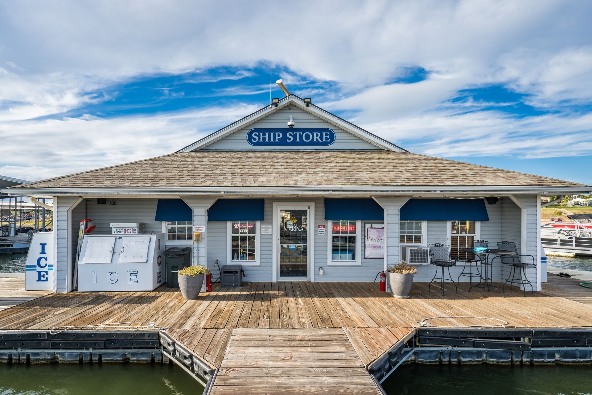 Front view of a grey wooden ship store at a marina with ice machines on the wooden deck at Shangri-La Resort and Golf Club