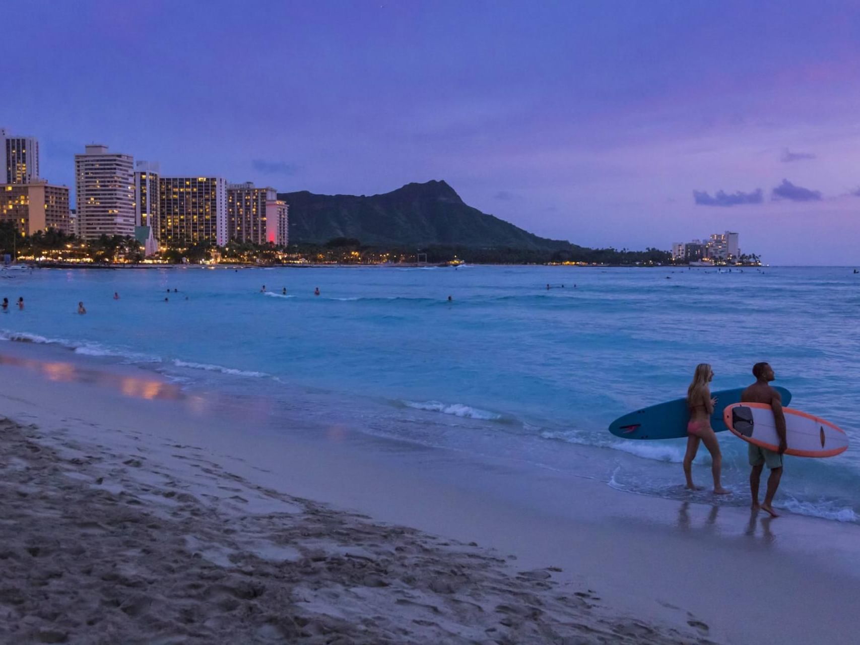 People enjoying on the Waikiki Beach at night near Waikiki Resort Hotel by Sono