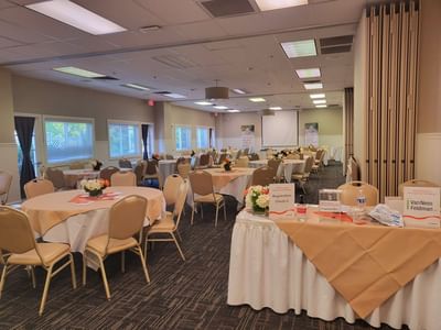 Sutter Room featuring round tables with peach linens and floral centerpieces at Lake Natoma Inn