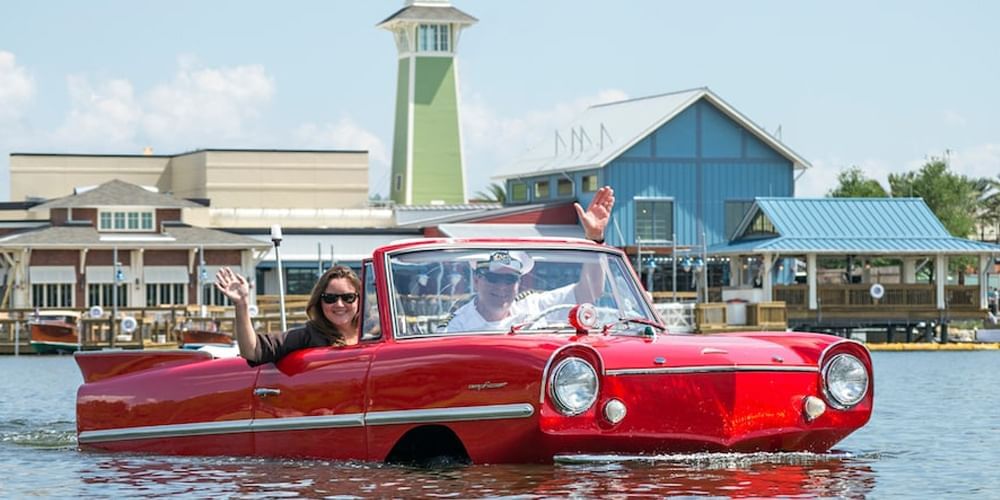 Red amphibious car with passengers on the water near Lake Buena Vista Resort Village & Spa