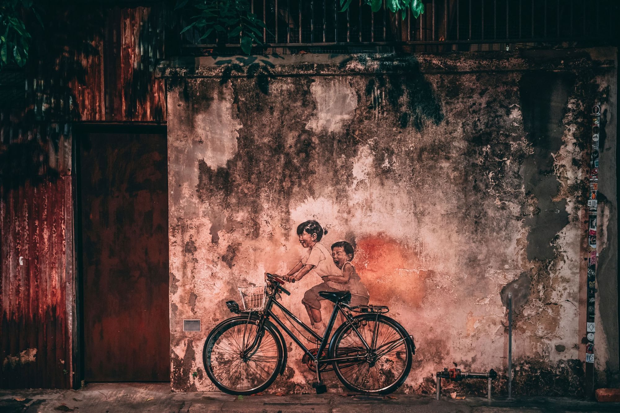 Wall art of a girl & boy riding a bicycle near The Banjaran Hotsprings Retreat