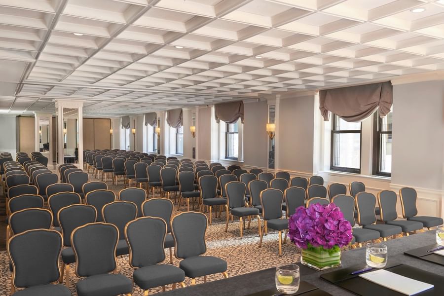 Theater style Kent Surrey Oxford with numerous rows of chairs facing desk on floral centerpiece at Warwick New York