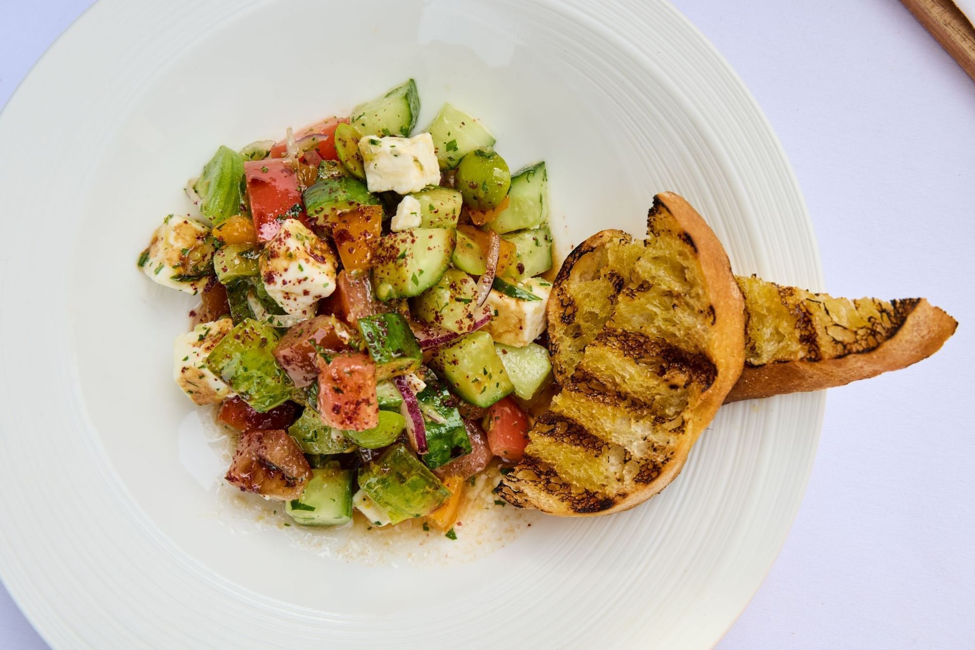 Fresh colourful salad with cheese and toasted bread perfect for a light meal in Whitcomb's Terrace at The Londoner Hotel
