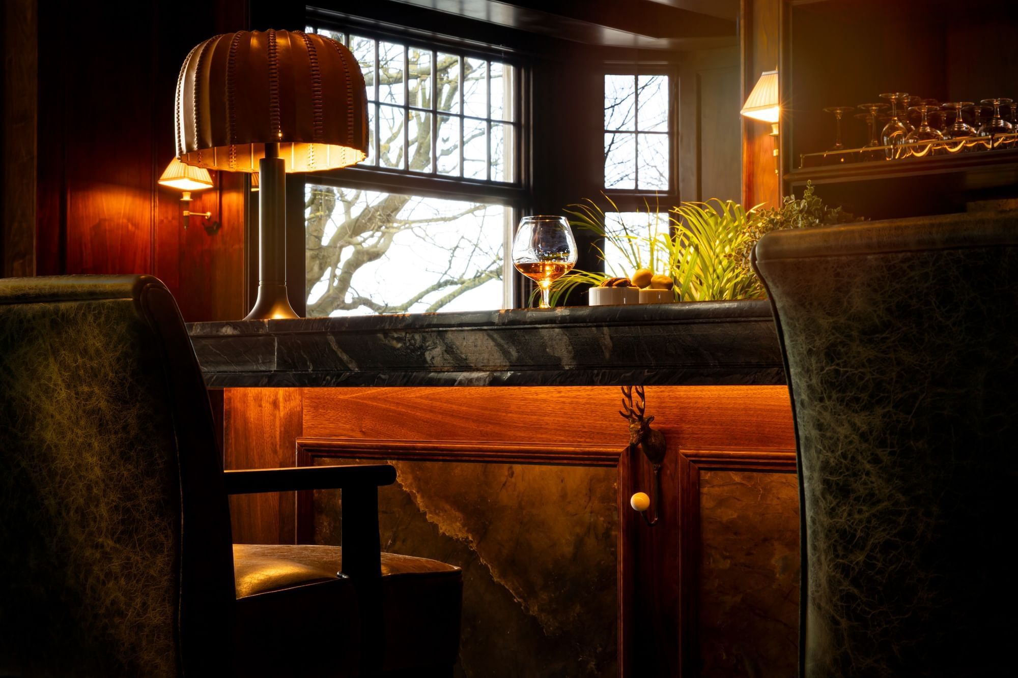 close-up of a Bow Butts, with a glass of scotch and a unique bronze lamp at Seaton House