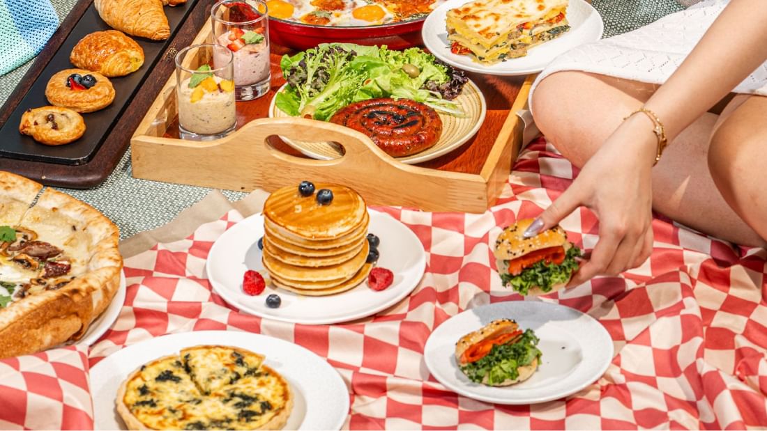 A delightful breakfast picnic spread on a checkered blanket, featuring pancakes and other dishes at Sunway Hotel Pyramid