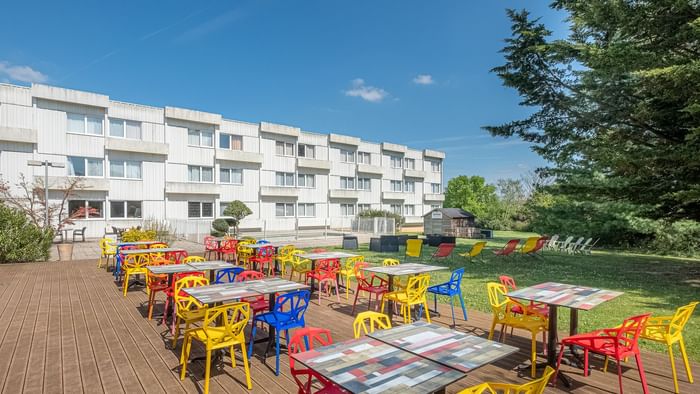 Outdoor dining area in a restaurant at The Originals Hotels