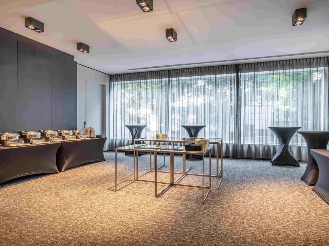 Park Ballroom with tables set up for a catered function, large windows, and elegant decor at The Hotel Brussels