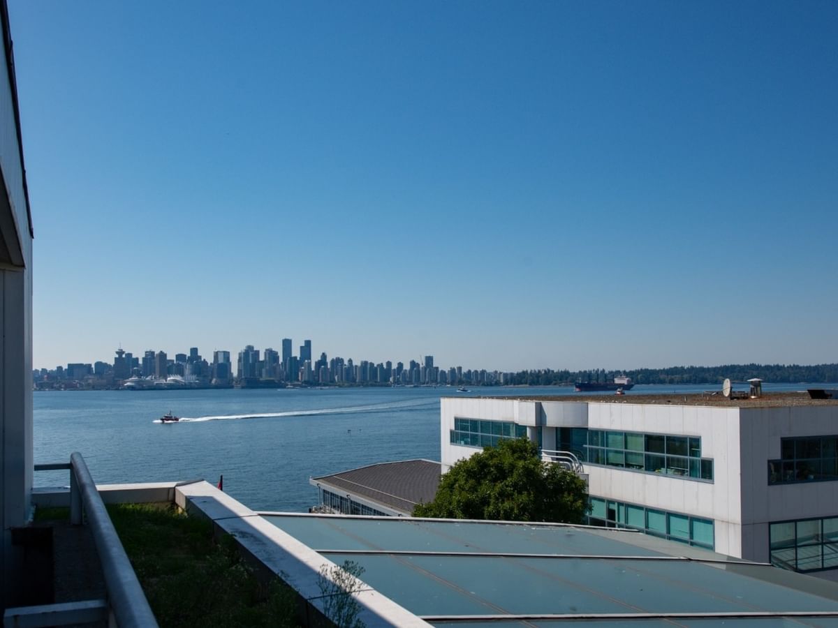 Elevated view from the balcony overlooking water and a distant city skyline of Vancouver at Coast Lonsdale Quay Hotel
