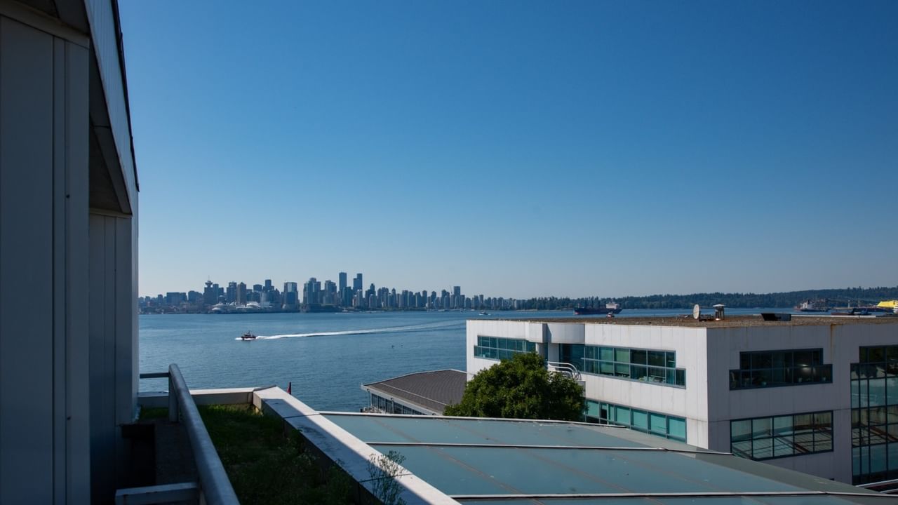 Elevated view from the balcony overlooking water and a distant city skyline of Vancouver at Coast Lonsdale Quay Hotel