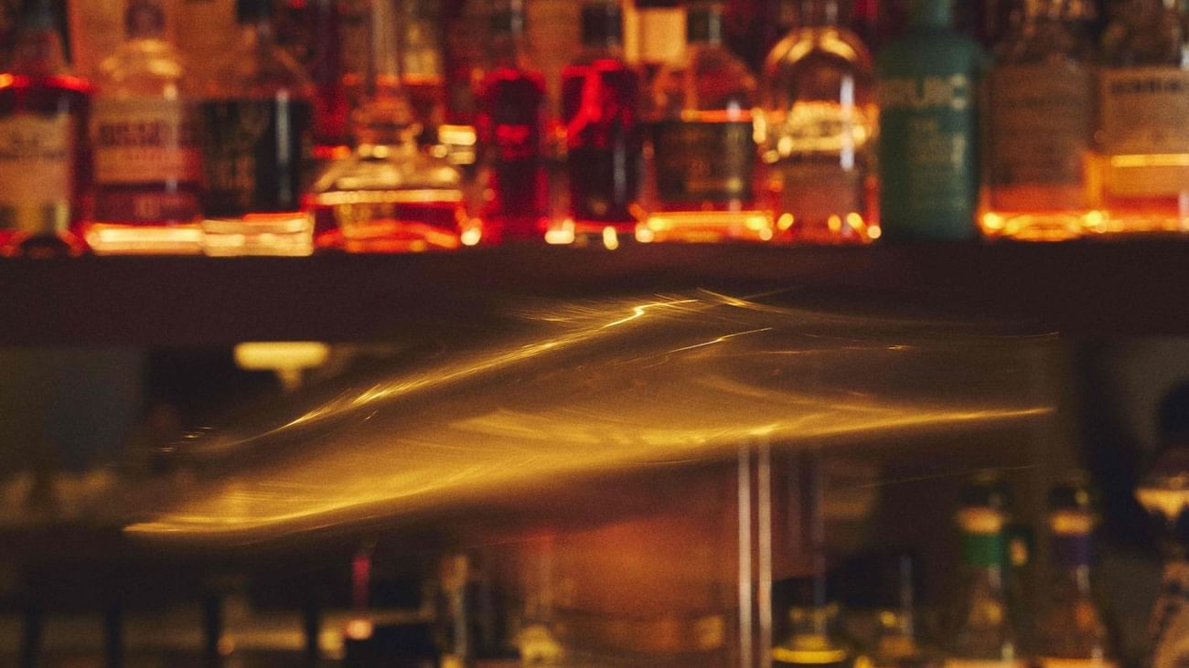 Blurry bar counter with bottles on shelves at BAR TILDA, Sofitel Sydney Wentworth.