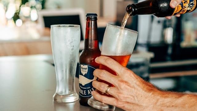 Close up on a man pouring beer to a glass at Mercure Charlestown
