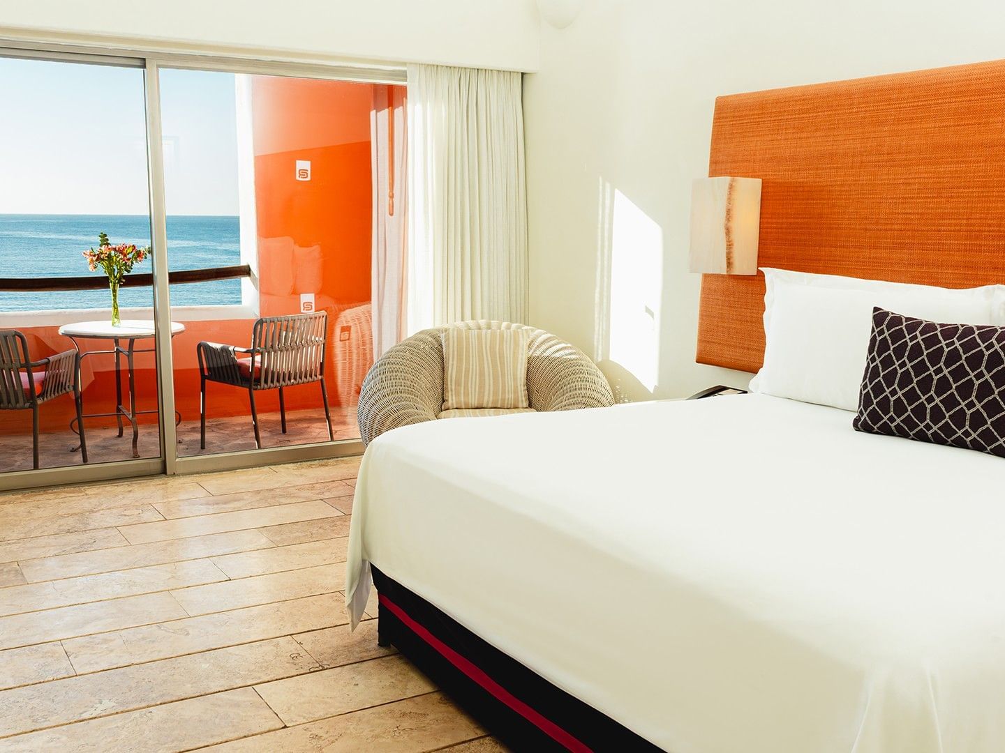 Cozy lounge chair and private balcony with an ocean view in King Deluxe Bed at Camino Real Zaashila Huatulco