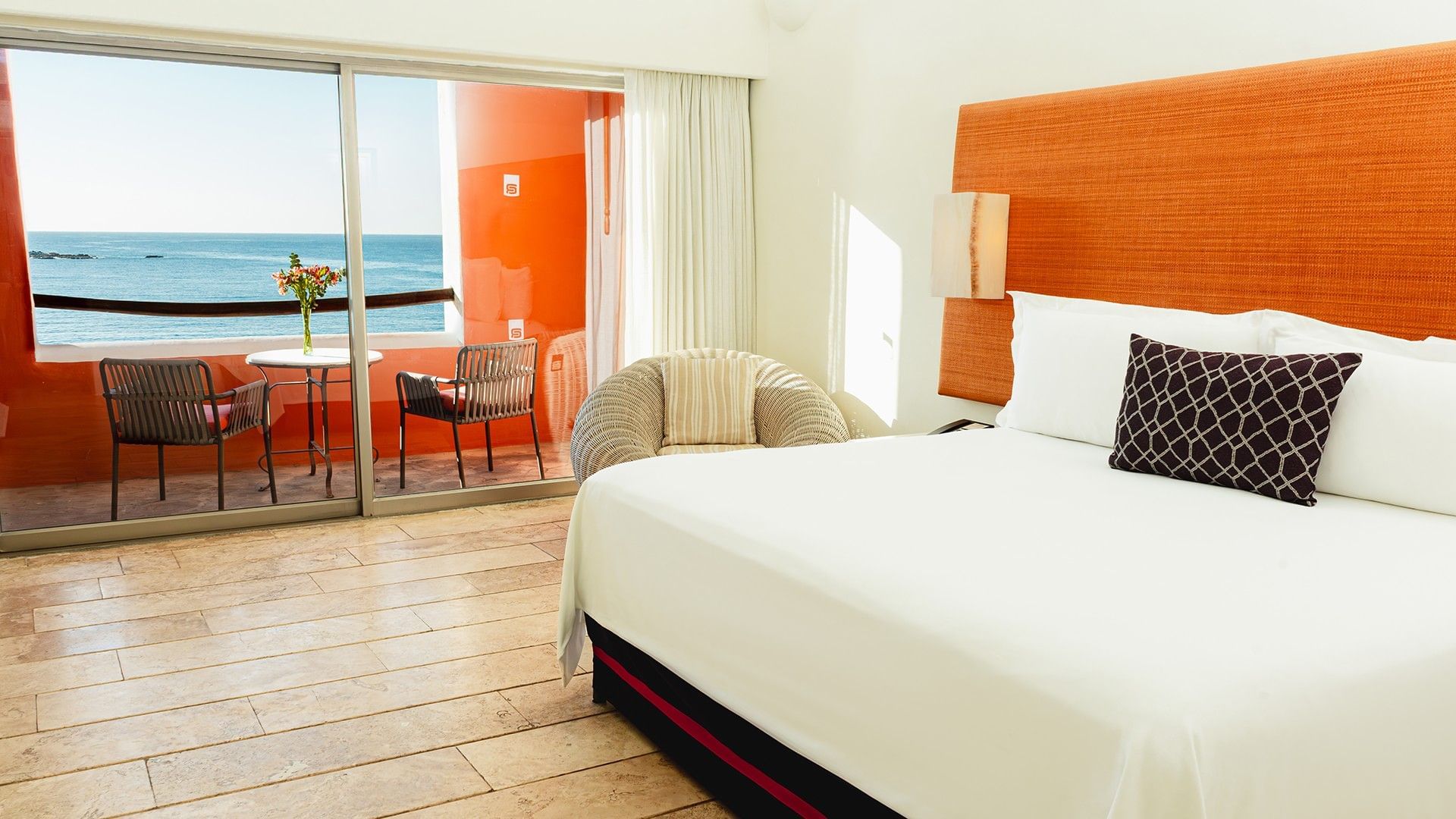 Cozy lounge chair and private balcony with an ocean view in King Deluxe Bed at Camino Real Zaashila Huatulco