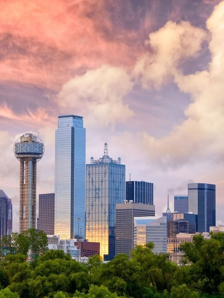 La silhouette de Dallas au coucher du soleil, avec l'emblématique Reunion Tower et les gratte-ciel situés près des hôtels Warwick Hotels & Resorts