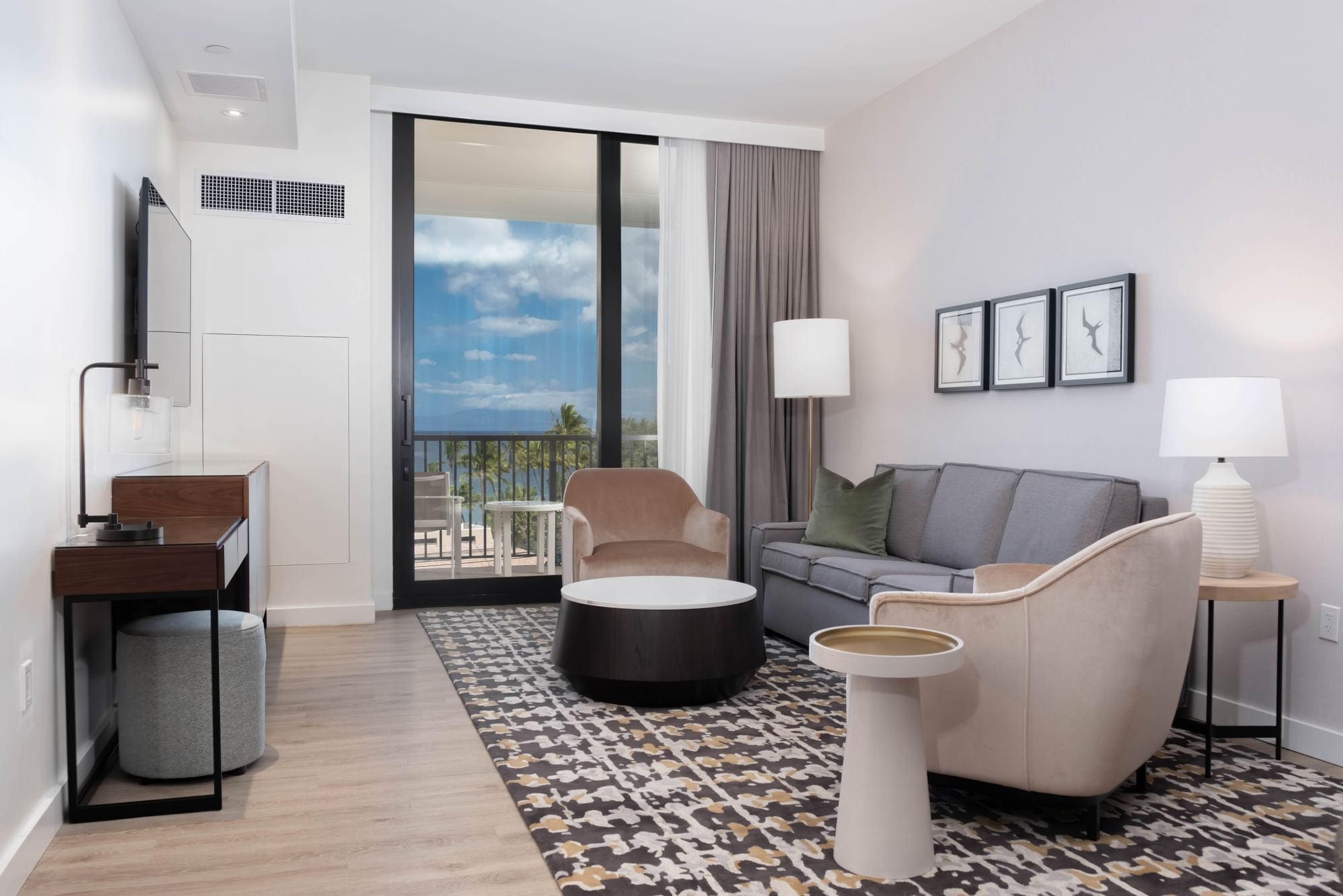 A wide view of a hotel suite's living area with a balcony