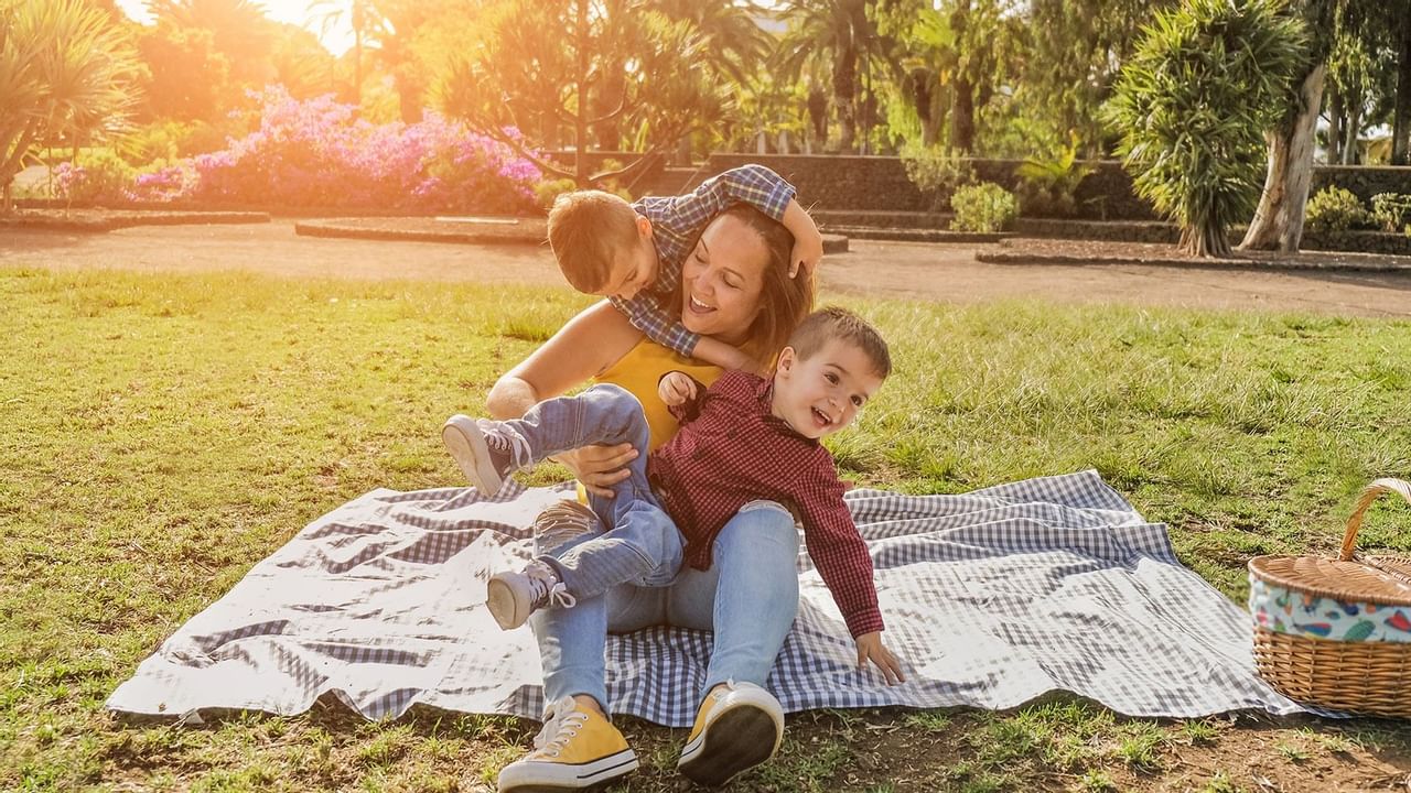 Family of three climbing on mon in a park