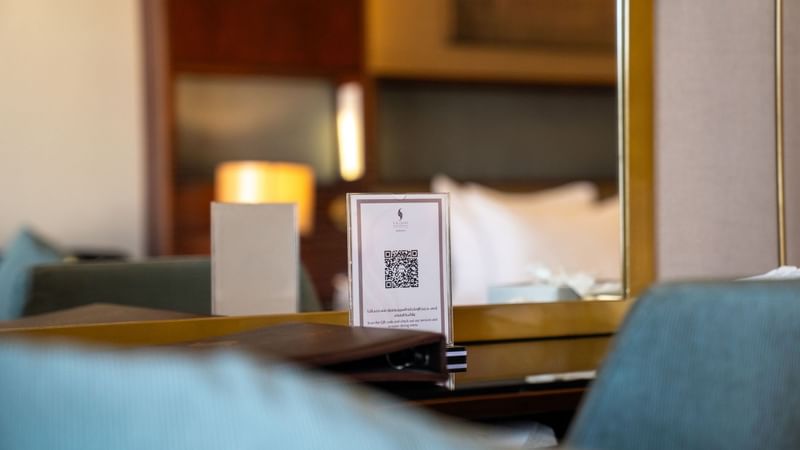 Executive King Room with a menu card and QR code in the foreground at Saja by Warwick Madinah.