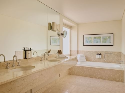 Bathroom with a marble counter, bathtub, and art on the wall in Signature Suite at Sofitel Brisbane Central