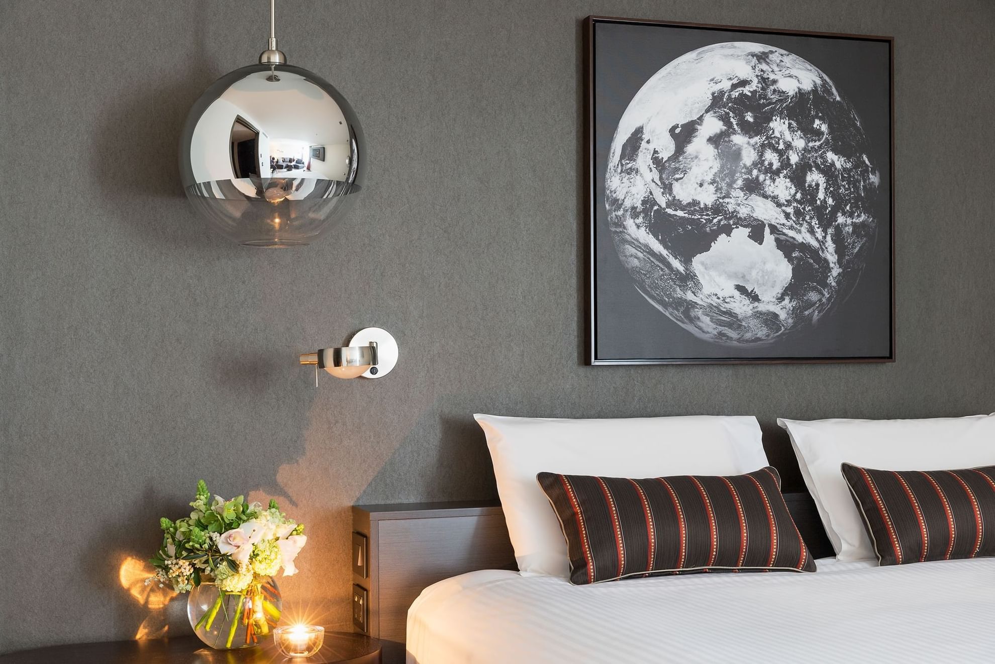 Close-up of king bed and comfy pillows in Deluxe Room with hanging chandeliers at Pullman Albert Park