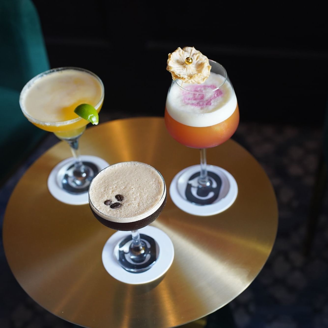 Craft cocktails on a round brass table between armchairs at Courtleigh Hotel & Suites, the best hotel in Kingston, Jamaica