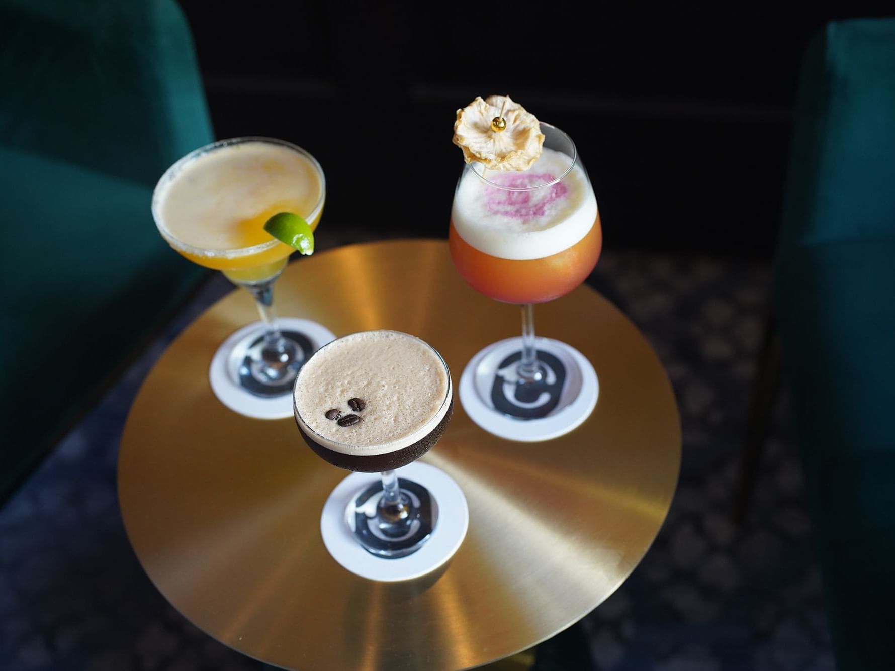 Craft cocktails on a round brass table between armchairs at Courtleigh Hotel & Suites, the best hotel in Kingston, Jamaica