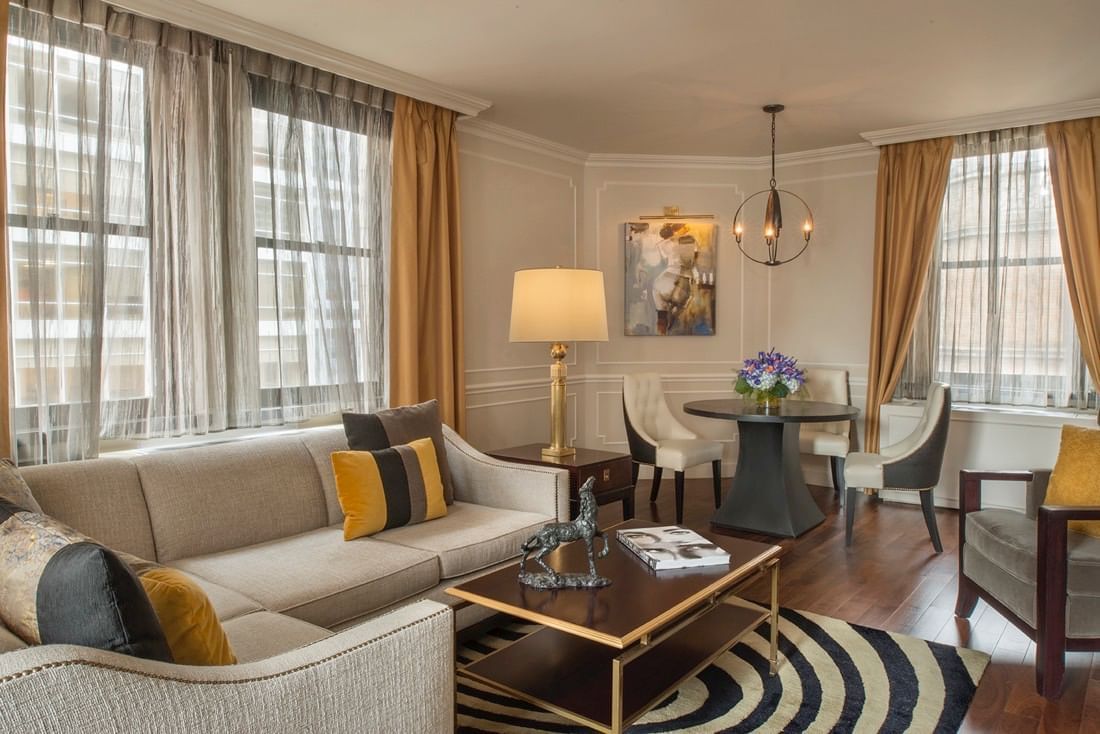 Chic living space with a tan sectional sofa with table and beside dining area beside in Jane Suite at Warwick New York