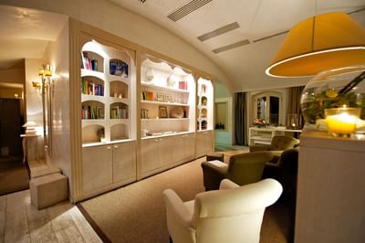 Bookshelves & comfy chairs in the lobby area at Grand Visconti Palace