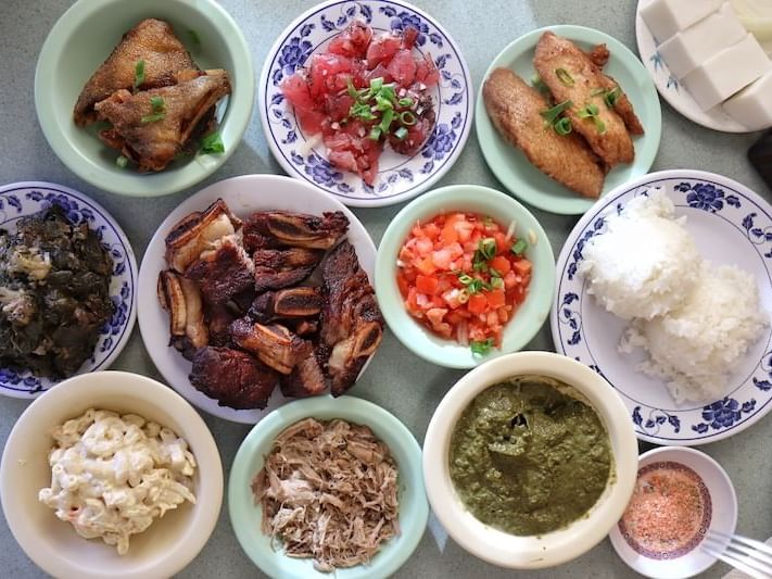 Variety of food dishes served on a table in Helena's Hawaiian Food near Waikiki Resort Hotel