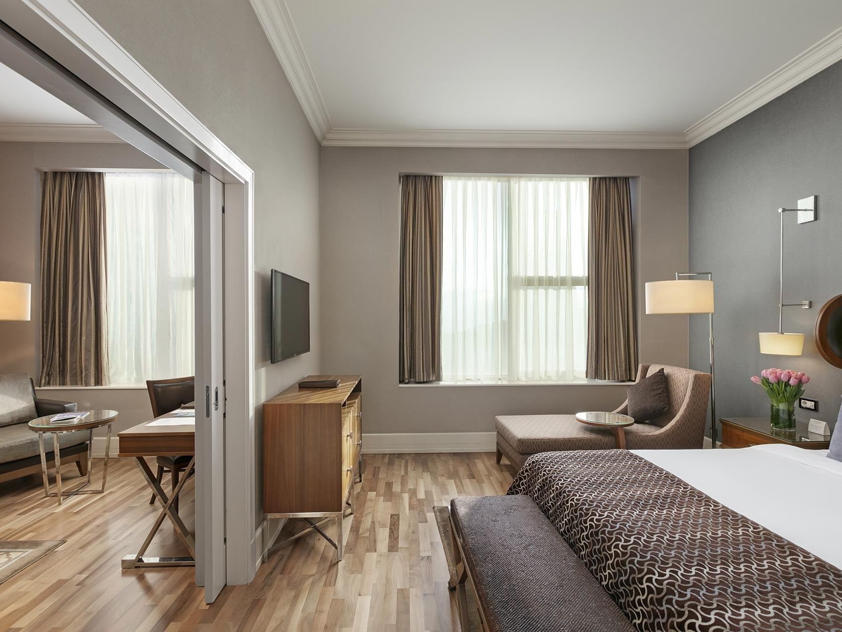 Titanic Business Kartal’daki Premier Suite’te, rahat yatak, tekli koltuk ve televizyon.