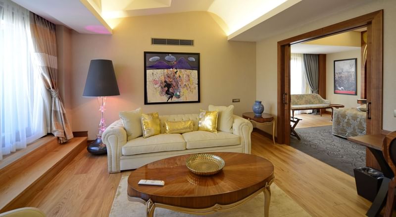 Warwick Suite with Terrace features Cream sofa and gold pillows by an oval wooden table at Warwick Ankara