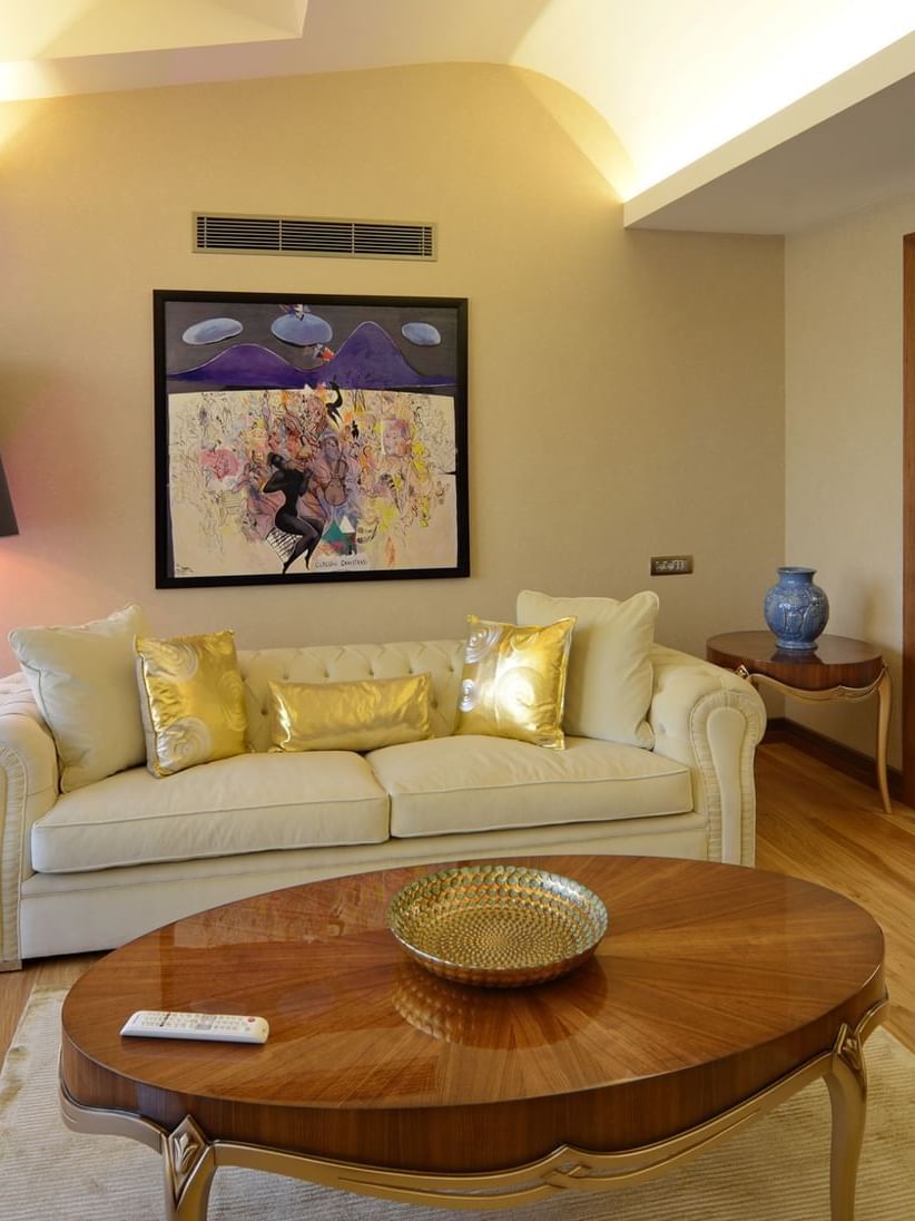 Warwick Suite with Terrace features Cream sofa and gold pillows by an oval wooden table at Warwick Ankara