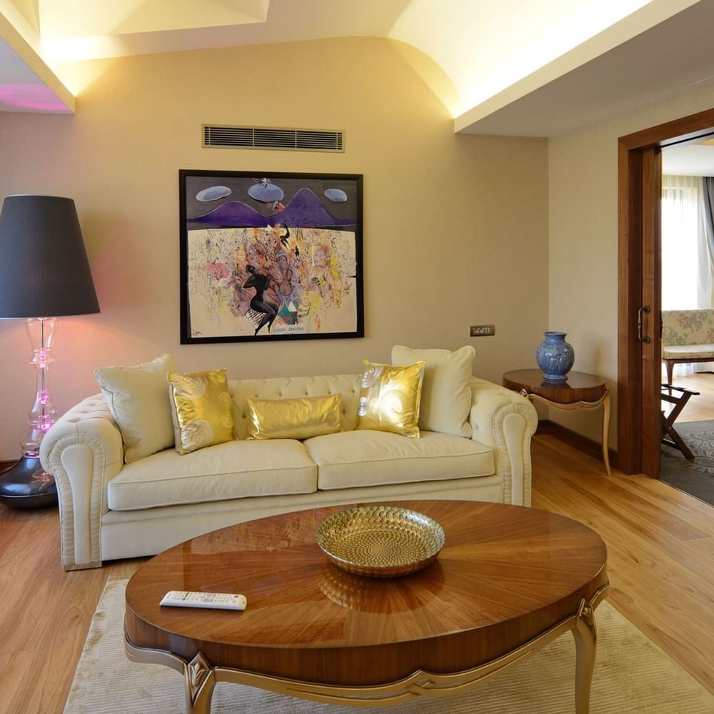 Warwick Suite with Terrace features Cream sofa and gold pillows by an oval wooden table at Warwick Ankara