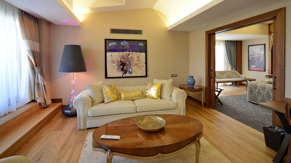 Warwick Suite with Terrace features Cream sofa and gold pillows by an oval wooden table at Warwick Ankara