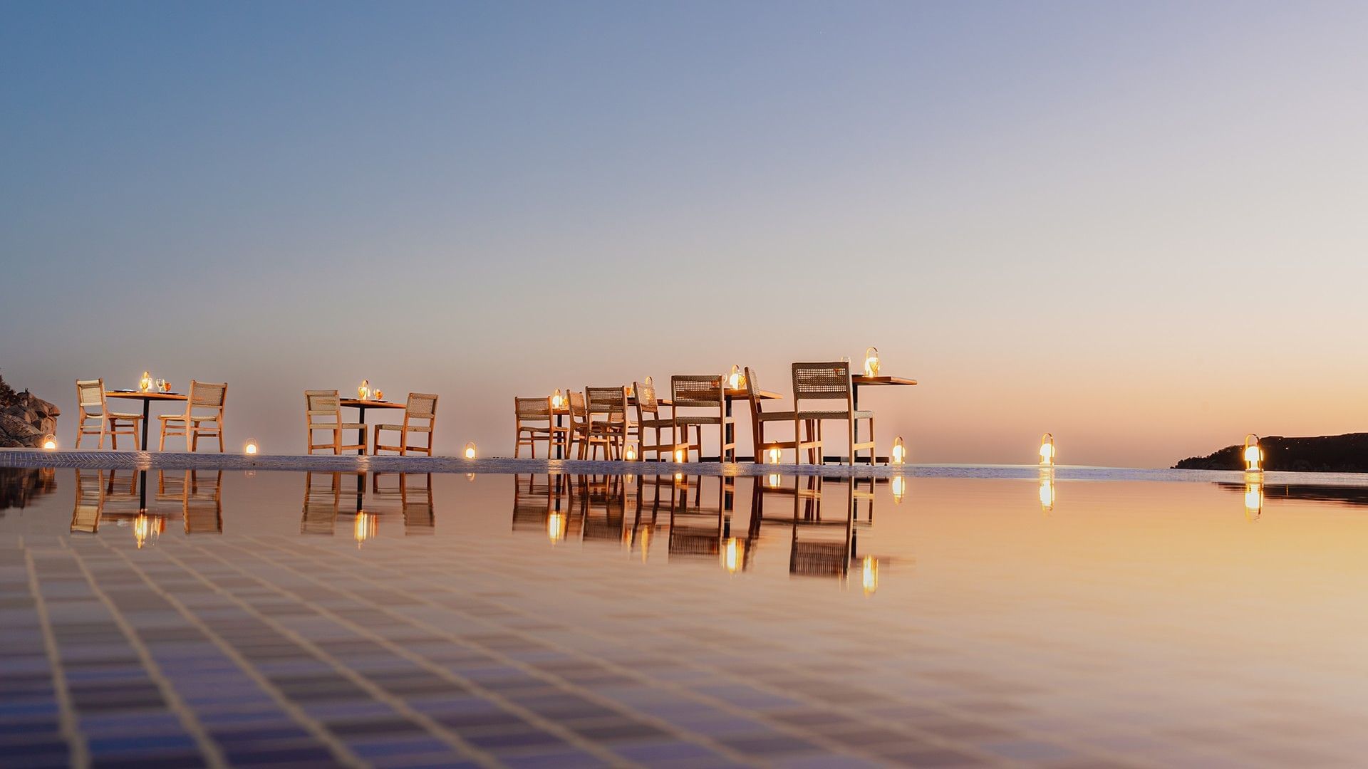 Open-air dining area decorated with lanterns by the pool in Azul Profundo at Camino Real Zaashila Huatulco
