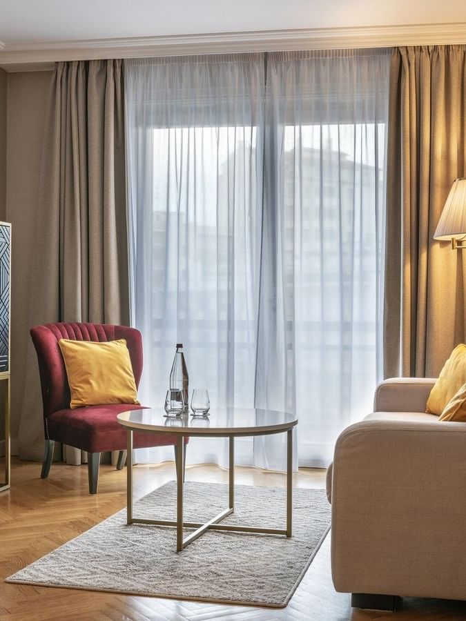 Living area with side cupboard and plush seating in the Premium Suite at Warwick Reine Astrid - Lyon